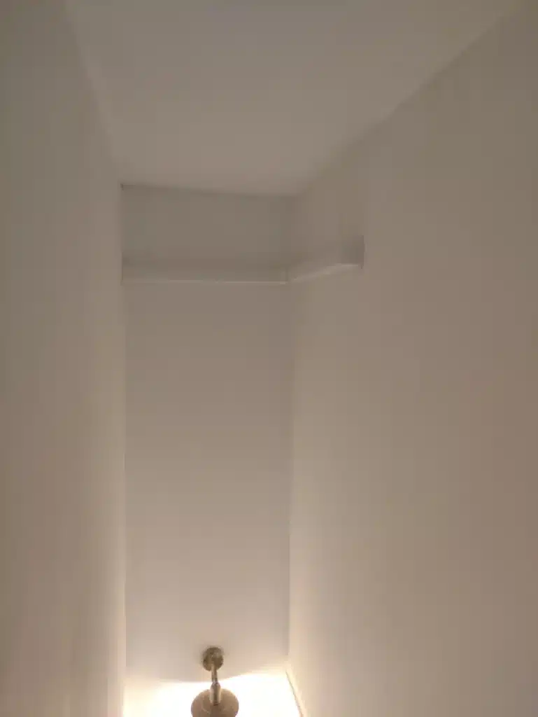 Goulotte blanche discrète en haut de la cage d'escalier pour les liaisons frigorifiques d'une clim à Montgiscard